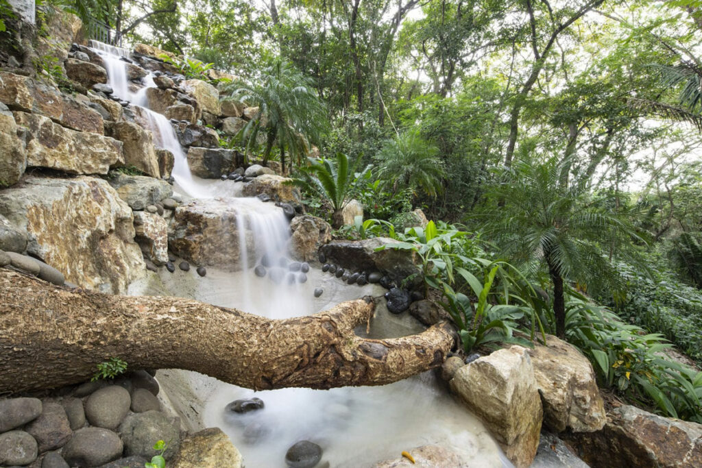 Small waterfall with trees and rocks.